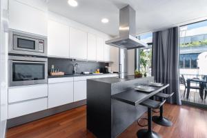 a kitchen with white cabinets and a black counter top at Aspasios Paseo de Gracia Apartments in Barcelona +16 photos