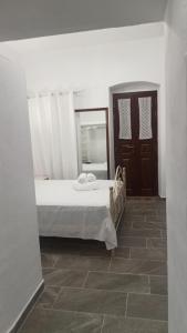a small bedroom with a bed and a mirror at Ξενοιασιά in Kithnos