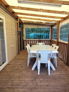 a white table and chairs on a deck at Mobil Home Les Charmettes 321 in Les Mathes