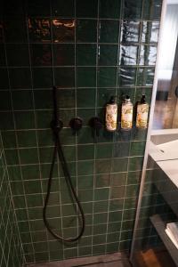 a shower with a hose in a green tiled bathroom at Santo Thyrso Hotel in Santo Tirso +38 photos