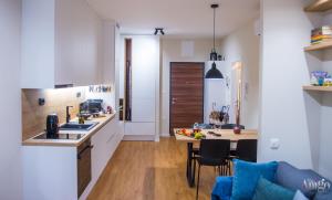 a kitchen and living room with a table and a couch at Iris Studio Apartment in Mostar