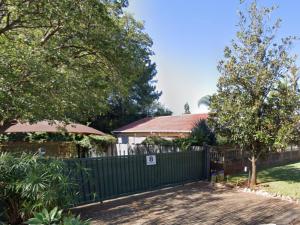 a green fence in front of a house at 8 Soenie Avenue Self-Catering in Pretoria
