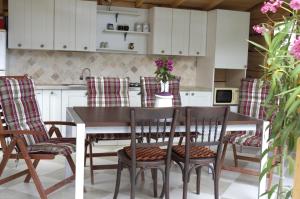 a kitchen with a wooden table and chairs at CASA Apusul Soarelui in Eforie Nord