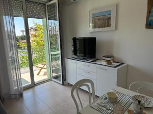 a living room with a television and a table with chairs at Appartamento delle Vele in Bellaria-Igea Marina