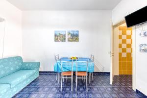 a dining room with a blue table and chairs at studio Apartment mono Glicine with Private Garden in Torre Pali 