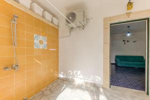 a bathroom with a shower and yellow tiles at studio Apartment mono Glicine with Private Garden in Torre Pali 