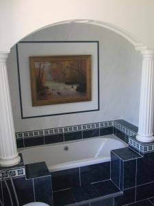 a bathroom with a tub and a painting on the wall at Domaine de La Bessade in Le Bugue +5 photos