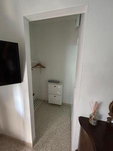 a hallway with a room with a dresser and a television at Casa Giulia in Porto SantʼElpidio