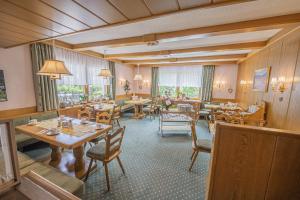 a restaurant with wooden tables and chairs and windows at Haus Anni in Bad Kleinkirchheim