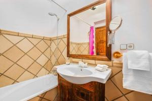 W łazience znajduje się umywalka, lustro i wanna. w obiekcie Villa Capistrano w mieście Nerja