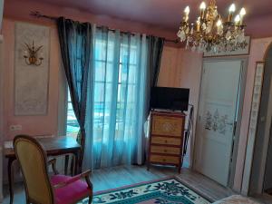 a living room with a chandelier and a table and a television at Studio Magenta in Vinça
