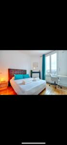 Un dormitorio con una cama y un escritorio y una ventana. en Victoria's House, en Nogent-sur-Marne