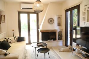 a living room with a couch and a fireplace at CasaSmaragdi in Perdika