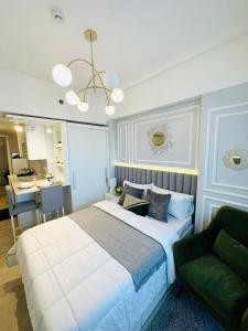 1 dormitorio con 1 cama grande y 1 silla verde en Le Monaco Suites - Azure North Pampanga, en San Agustin