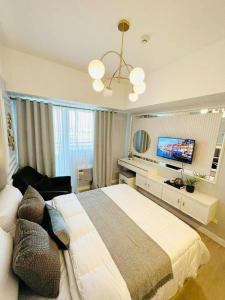 Un dormitorio con una cama grande y un televisor de pantalla plana. en Le Monaco Suites - Azure North Pampanga, en San Agustin 3 fotos más