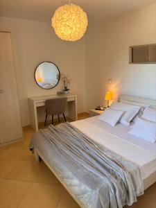 ein Schlafzimmer mit einem Bett, einem Schreibtisch und einem Spiegel in der Unterkunft Apartments Sanja in Hvar