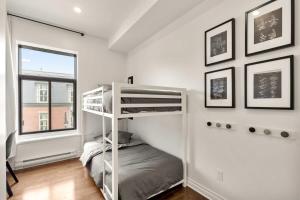 ein Schlafzimmer mit Etagenbett und Fenster in der Unterkunft M11 The LEGO Suite 2BRSofaBed in Prime Location in Montreal