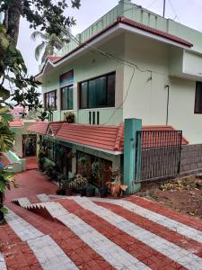 una casa con un passaggio di mattoni rossi di fronte di Basuri Beach Resort a Varkala