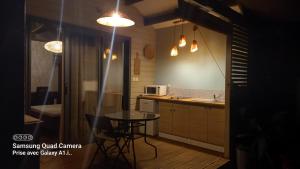 een kleine keuken met een tafel en een magnetron bij Le latanier bleu in La Saline les Bains