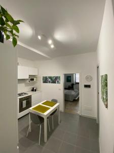 a white kitchen with a table and chairs in it at Casa Vita Scilla in Scilla