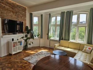 a living room with a couch and a table at Apartamenty pod Aniołami in Ostrów Wielkopolski