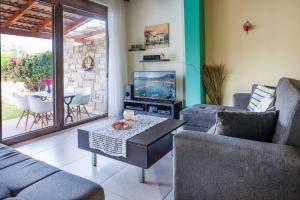 Una sala de estar con sofás, un televisor y una mesa. en Villa Portokalia Platanias, en Plataniás