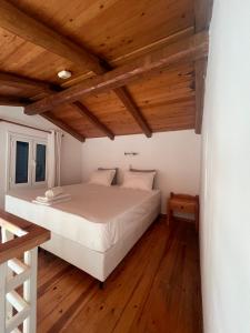 a bedroom with a white bed in a room with wooden ceilings at Marianthi Apts Anissaras in Hersonissos +43 photos
