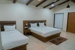 a bedroom with two beds in a room at Flamingo Club and Resort Una 3 Km Away from Diu Check Post in Diu