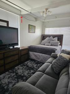a living room with two beds and a flat screen tv at Beach House-Town House in Eden +32 photos
