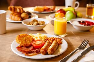a table with plates of breakfast food on it at Holiday Inn Express London - ExCel, an IHG Hotel in London