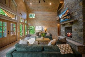 a living room with a couch and a fireplace at Pet friendly family cabin with firepit creek outdoor kitchen playset & more in Broken Bow