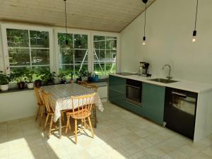 a kitchen with a table and chairs in a kitchen at Kristinebjerg in Jelling