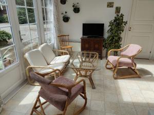 a living room with chairs and a tv and a table at Kristinebjerg in Jelling