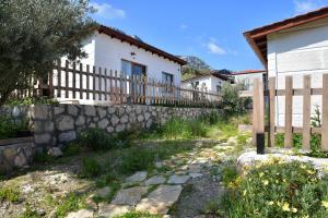 a house with a fence and a stone wall at KAVURLUKOZ KaraburuN in Karaburun