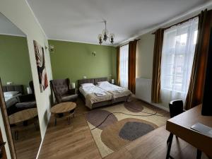 切霍齐内克Willa Zachęta Guesthouse&Coffee的一间卧室，里面有一张床、一把椅子和一张桌子
