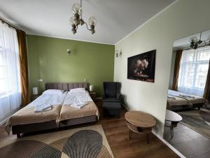 切霍齐内克Willa Zachęta Guesthouse&Coffee的一间卧室，里面有一张床、一把椅子和一张桌子
