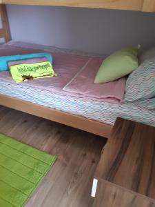 a bed with a yellow pillow and pillows on it at The Countryside Retreat in Rankovce