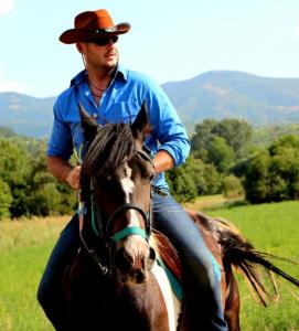 a man riding a horse in a field at The Countryside Retreat in Rankovce