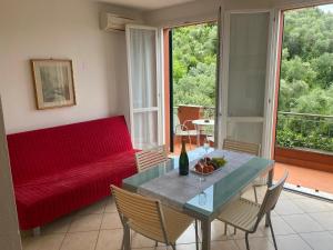 a living room with a red couch and a table at Oasi Verde 1 in Lerici