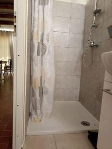 eine Dusche mit einem weißen Duschvorhang im Bad in der Unterkunft Studio privé - maison de village in Valensole