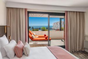a bedroom with a bed and a view of the ocean at Hôtel Barrière Le Gray d'Albion in Cannes