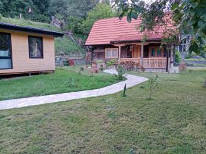 a house with a walkway in front of a yard at Brvnara Etno Lux in Mokra Gora