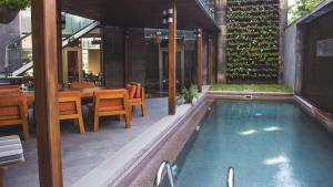 una piscina all'aperto con tavolo e sedie e un ristorante di Tufenkian Historic Yerevan Hotel a Yerevan