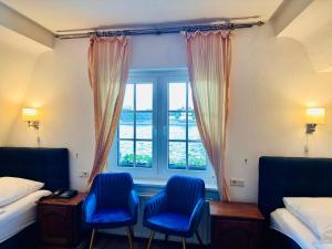 two blue chairs in a room with a window at Altstadthotel Hayk am Rhein in Cologne