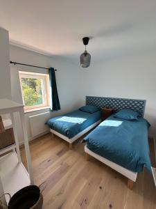 a bedroom with two beds and a window at Les Marais Blancs à Picauville in Picauville
