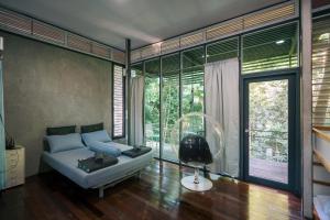 a living room with a couch and a large window at Sometimes Khaoyai in Ban Muak Lek Nai +75 photos