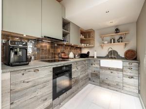 a kitchen with wooden cabinets and a sink at Chalet Cecilia inklusive Spa- Area in Obergurgl
