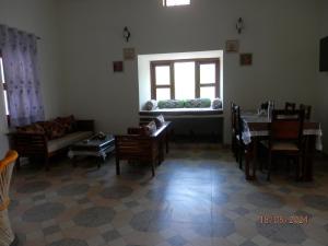 a living room with a couch and a table and a window at Sariska Farms in Tehla