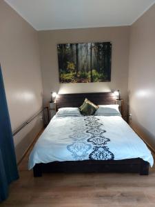a bedroom with a bed with a picture on the wall at Kesklinna korter in Kuressaare
