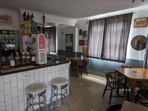 a bar in a restaurant with tables and stools at The Fox in Bristol